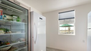 A kitchen with a refrigerator, a window with an umbrella, and a tiled floor. - Bring the whole family! 7 Bdrm, nice deck, big dock, close to fast water (Discovery Bay)