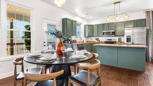 A modern kitchen with green cabinets, a central island, and stainless steel appliances. - Mntn & Asheville Views! Movie Theater! Game Rm! Hot Tub! Fire Pit! Pets Welcome! (Candler)