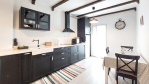Una cocina moderna con armarios oscuros, una encimera blanca y un tapete a rayas.