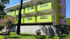 A modern multi-story building with balconies, surrounded by greenery and trees. - Extra Comfort in Bibione Spiaggia-beahost (San Michele al Tagliamento)