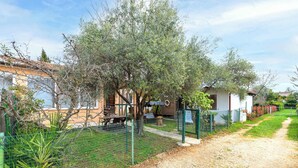 A fenced outdoor area with a gravel path, a wooden bench, and a picnic table. - Holiday apartment Cheap accommodation in a great location (Bašanija)
