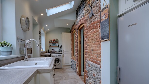 A kitchen with a sink, washing machine, and a refrigerator. - Bulmer Cottage | Dog-Friendly Coastal Cottage, 10 Mins Walk to Beach (Winterton-on-Sea)