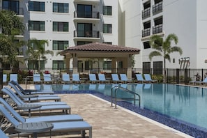 Relax by the pool surrounded by comfortable lounge chairs and a covered seating area.