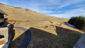 A winding road leading to a hillside with a building on the left. - 5159A (Besse-et-Saint-Anastaise)