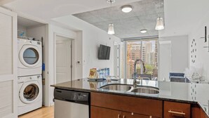 Una cocina moderna con lavavajillas, doble pila y lavadora-secadora integrada.