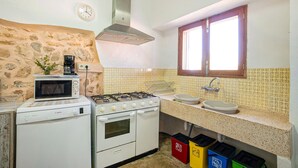 A compact kitchen with a stove, oven, microwave, and a sink.