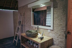 A bathroom with a stone sink, wooden vanity, and a ladder. - Villa Parianca (Canggu)