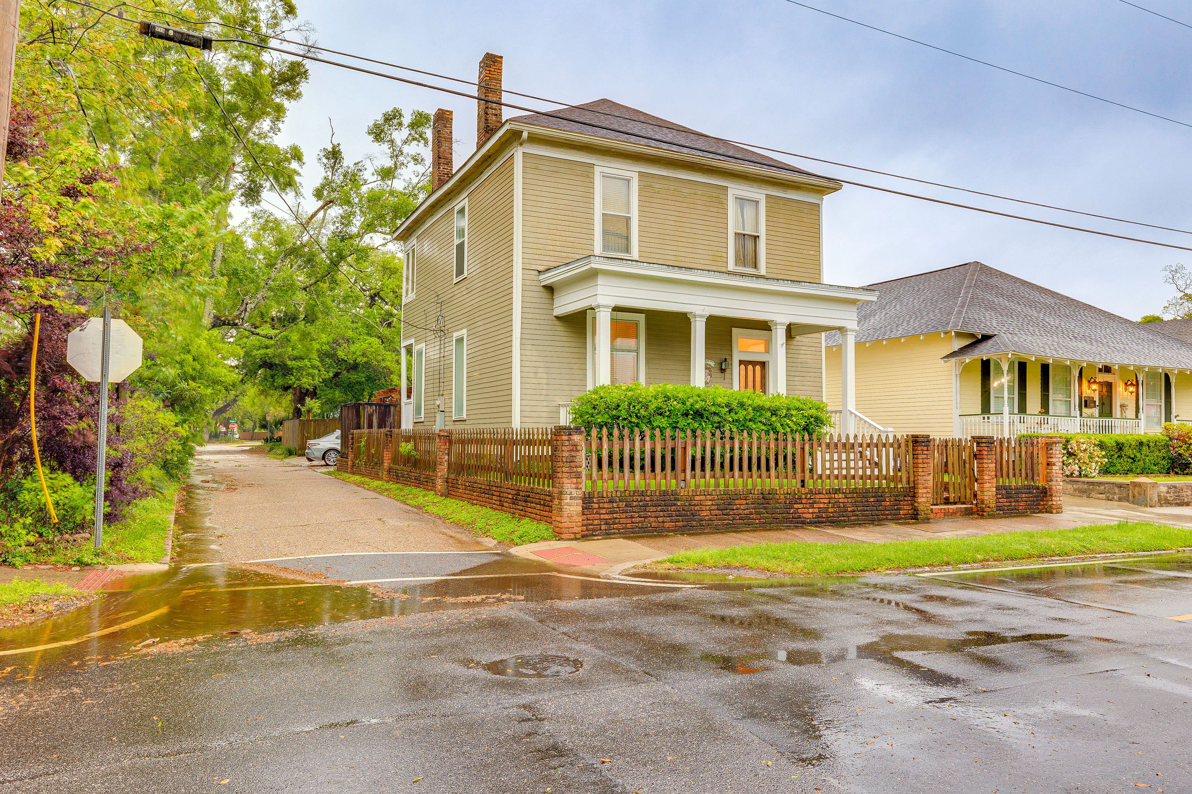 A two-story house with a porch and a fenced yard.