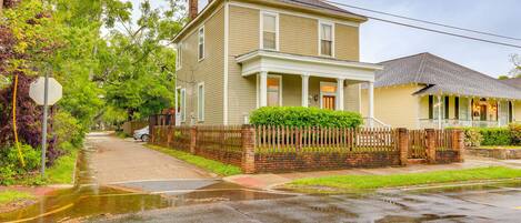 A two-story house with a porch and a fenced yard.