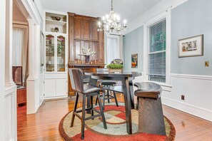 Un coin repas avec une table ronde, des chaises et un lustre.