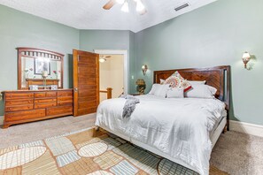 Une chambre à coucher avec un lit, une commode et un miroir.