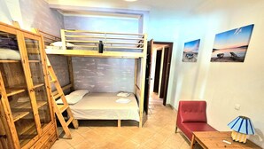 A bunk bed with a ladder, a red chair, a small table with a lamp, and a wall with two pictures. - ALGARVE ONE - Sports & Wellness Oasis, Volleyball, Billiards (Carvoeiro)
