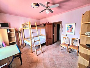 A room with bunk beds, a desk, a chair, a bookshelf, a ceiling fan, and a door. - ALGARVE ONE - Sports & Wellness Oasis, Volleyball, Billiards (Carvoeiro)
