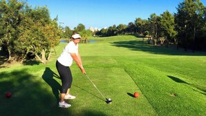 A person on a golf course with a golf club and a ball. - ALGARVE ONE - Sports & Wellness Oasis, Volleyball, Billiards (Carvoeiro)