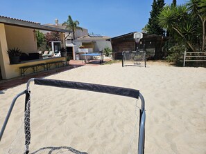 A sandy outdoor area with a basketball hoop and a table tennis table. - ALGARVE ONE - Sports & Wellness Oasis, Volleyball, Billiards (Carvoeiro)