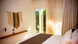 A hotel room with a bed, a wall-mounted telephone, and a window with curtains. - Grand Sirenis (Akumal)
