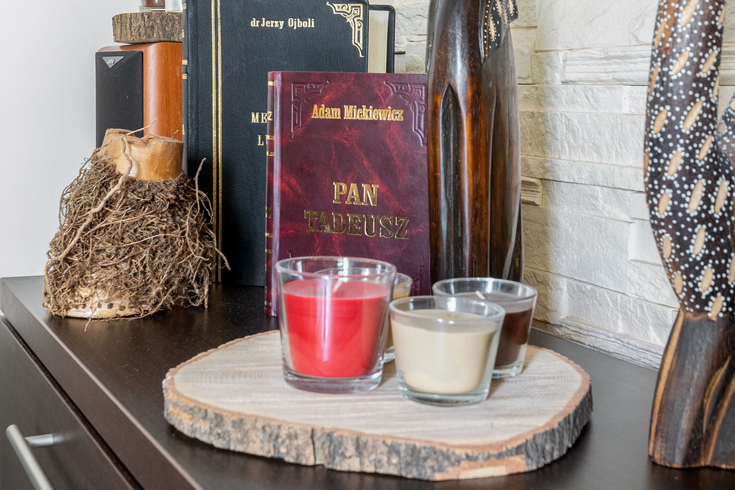 Ein Holztisch mit Büchern, Kerzen und einem dekorativen Gegenstand.