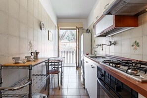 Une petite cuisine équipée d’une cuisinière à gaz, d’une machine à café et d’un évier.