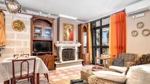 Un salon avec une cheminée, un coin repas et un canapé.