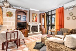 A living room with a fireplace, dining area, and a sofa. - GuestHost - Villa Ivana and Beatrice - Village S. Lucia Ostuni (Ostuni)