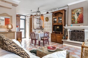 A cozy living room with a sofa, dining table, and fireplace.