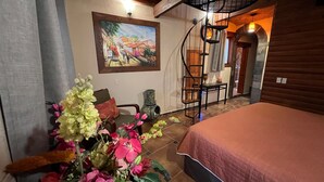 Un dormitorio con cama, una escalera y un cuadro en la pared.