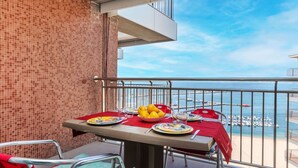 Ein Balkon mit Tisch für zwei Personen mit Blick auf eine Marina.