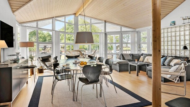 A spacious living area with a large window, a dining table, and modern furniture. - Pet friendly home in Farsø with WiFi (Farsø)