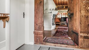 A rustic interior with a wooden door, a stone fireplace, and a patterned rug. - Vacation home Alice by Interhome (Tällberg)