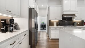 A modern kitchen with white cabinetry, stainless steel appliances, and a central island.