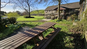 Et picnicbord i en græsplæne med en bygning i baggrunden.