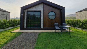 Ein modernes Haus mit großem Fenster und rundem Fenster, umgeben von gepflegtem Rasen und Kiesweg.