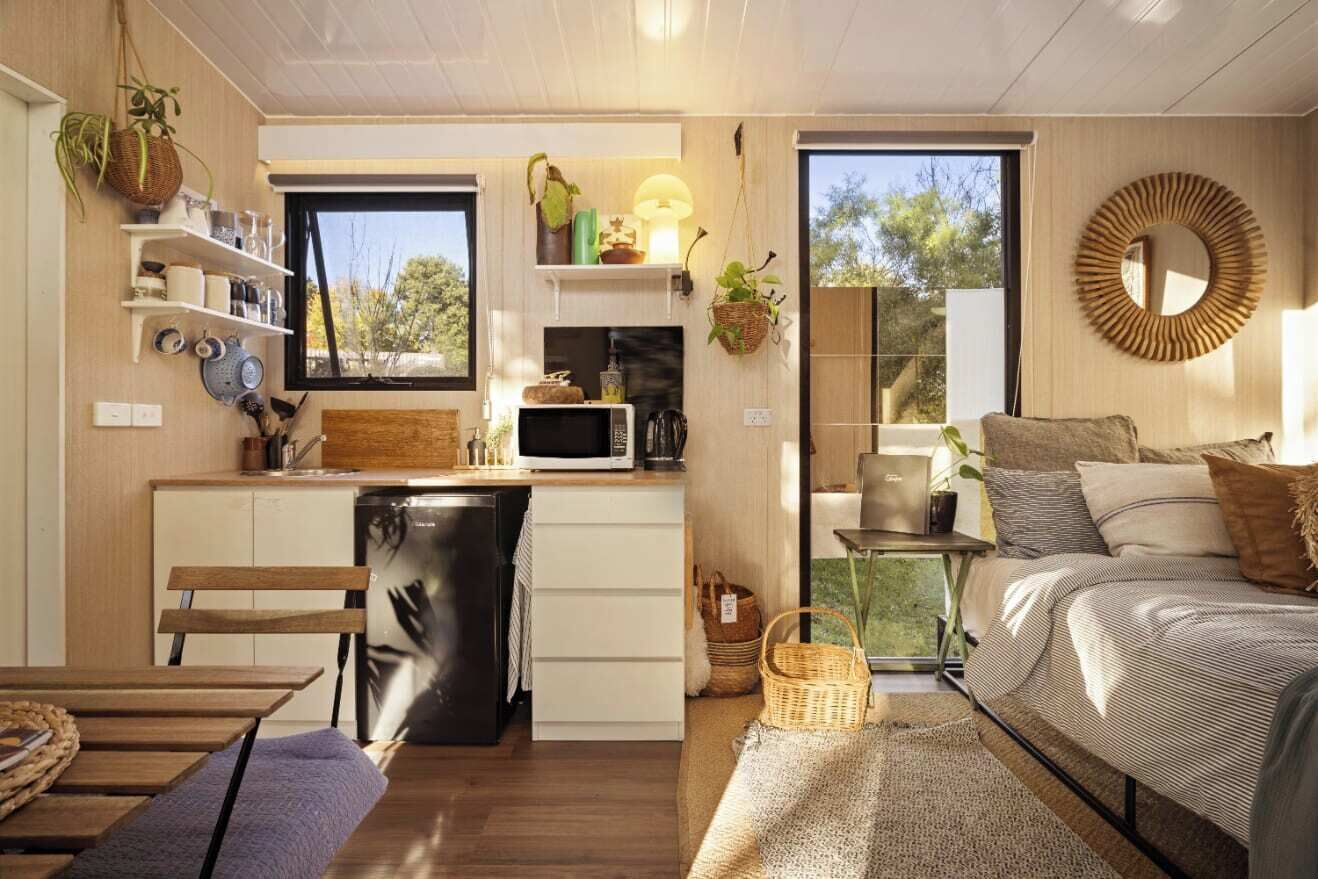 Un espacio habitable compacto con kitchenette, comedor y dormitorio.