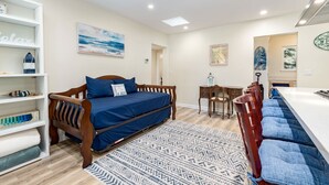 A bedroom with a bed, a desk, a chair, and a shelf with decorative items. - Redwood Home - view of the river! (Ben Lomond)