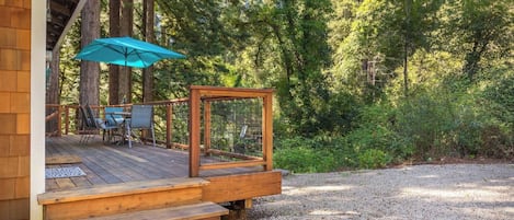 A wooden deck with outdoor seating and a birdcage.