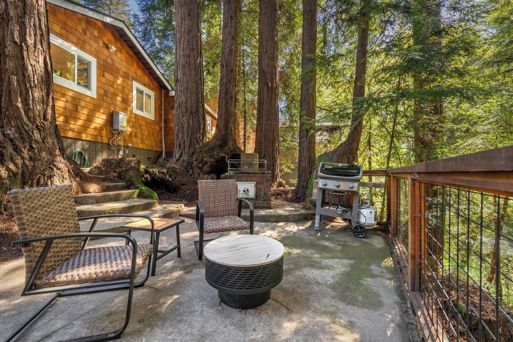 An outdoor patio with wicker furniture, a grill, and a wooden deck.