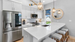 Una cocina moderna con electrodomésticos de acero inoxidable, una isla grande y vistas al exterior.