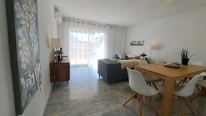 A modern living room with a sofa, a dining table with chairs, a coffee table, and a side table with a lamp. - Ref: 324 Centric 3 bedroom apartment with swimming pool and close to everything (Fuengirola)
