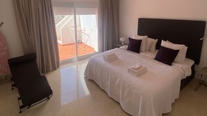 Une chambre d’hôtel avec un grand lit, une chaise et une vue sur l’extérieur.