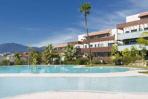A swimming pool with a clear view of a mountain range in the background. - Hoyo 3 | Marbella Resort Golf Pools Apartment (Benahavís)