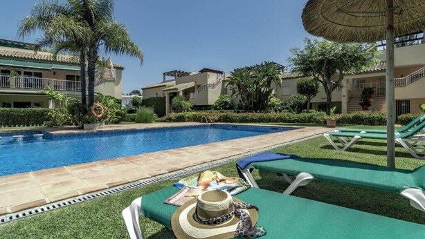 A pool area with lounge chairs, a pool, and palm trees. - Las Brisas | Penthouse Rooftop Terrace Pool Family Only (Marbella)