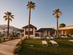 A resort with palm trees, lounge chairs, and a building labeled 'Elvis Beach.'