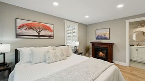 Ein Schlafzimmer mit Bett, Kamin und einem Bild an der Wand.
