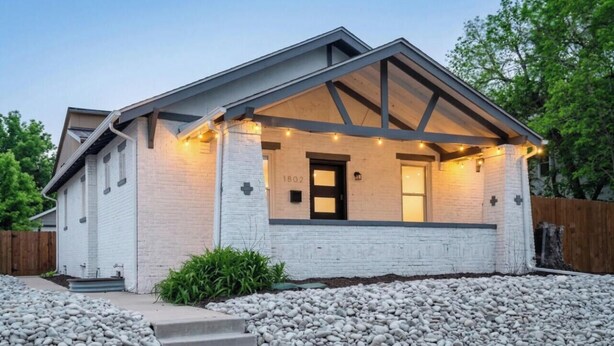 A house with a white exterior, a black door, and a number '1802' on the front wall. - Huge 6BR Highlands Home - Modern Style & Comfort (Denver)