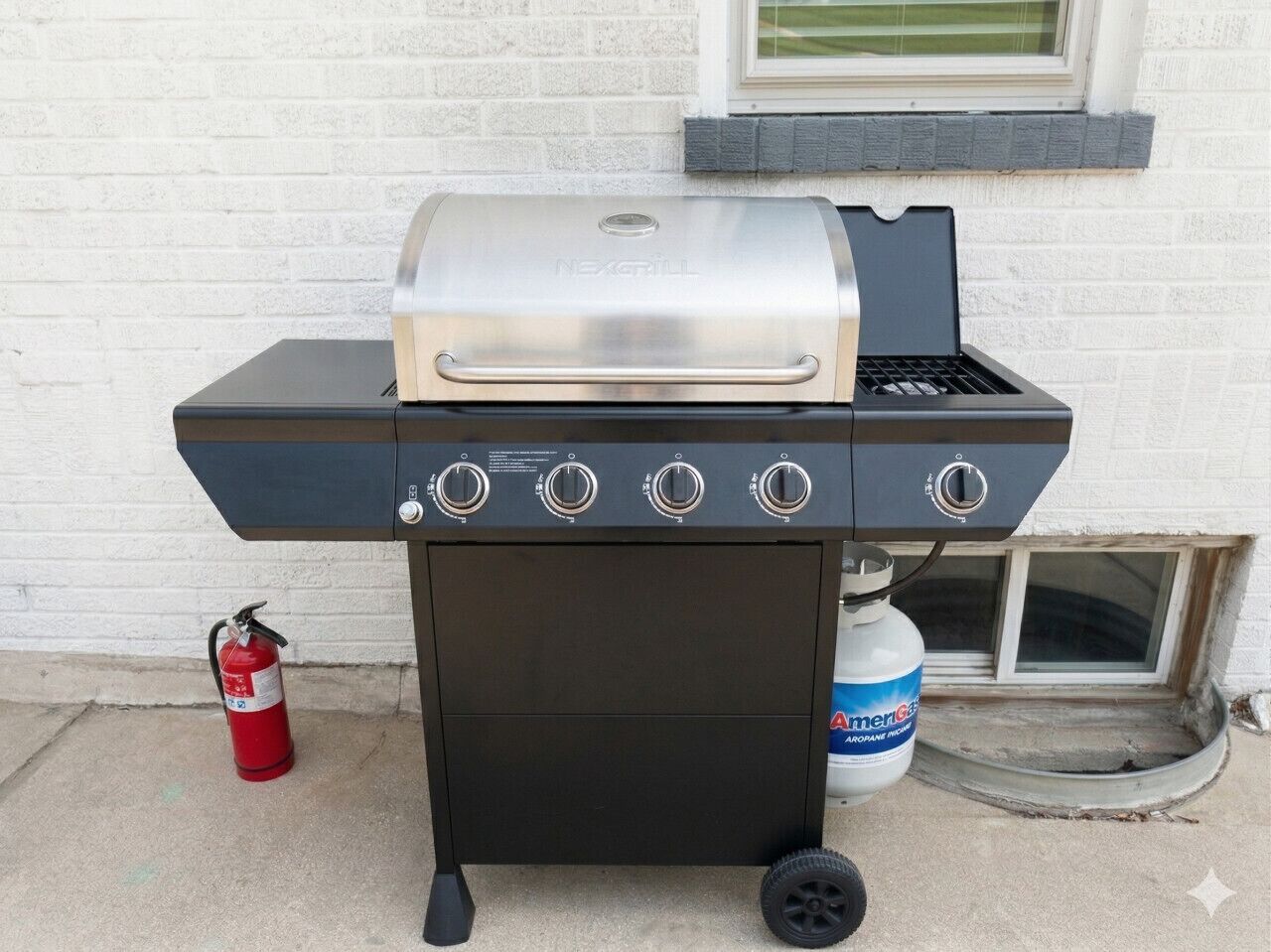 A portable grill with four burners, a side shelf, and a gas tank.