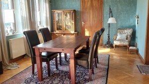 Un comedor con una mesa de madera, sillas, un armario y una lámpara.