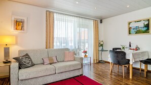 Una sala de estar moderna con un sofá, una mesa de comedor y un cuadro en la pared.