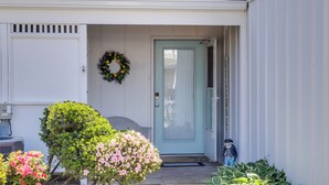 A house with a light blue door, a wreath on the wall, and a small statue of a person. - Porch & Water Views: Getaway in Mallard Lakes (Selbyville)