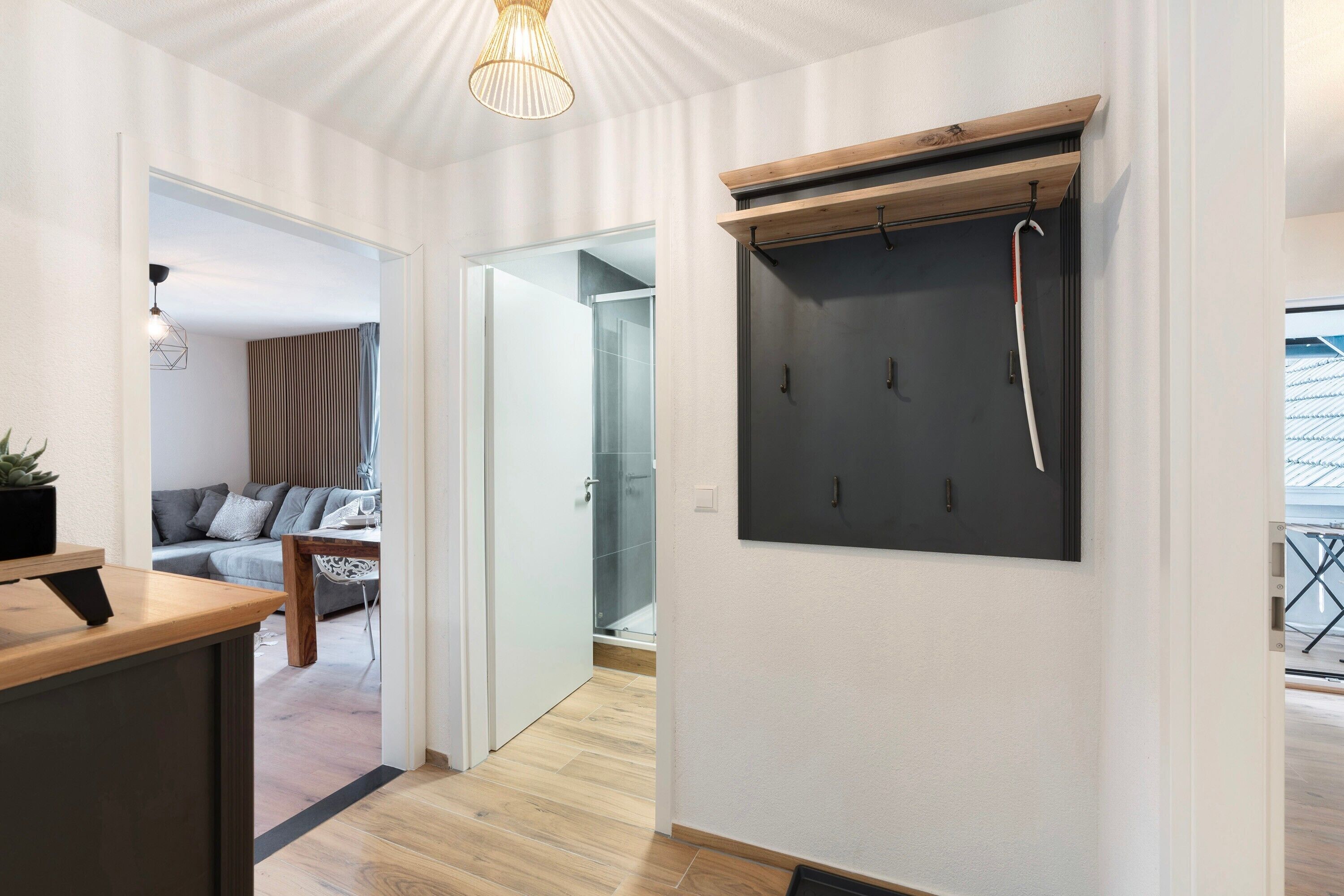 A modern interior with a wooden desk, a mounted TV, and a glass shower area.