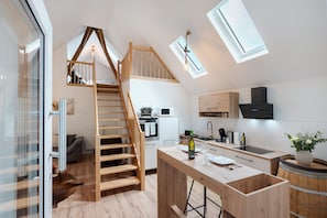 A modern kitchen with a wooden staircase, skylights, and a central island. - Holiday Home 'Bühlertal Mit 3 Fewos' with Mountain View, Private Terrace and Wi-Fi (Bühlertal)